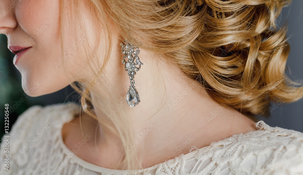Macro close-up of jewelry earrings and wedding hairstyle