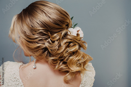 Rear view close-up of the finished wedding hairstyles in the form of winter bride with cotton flowers decoration