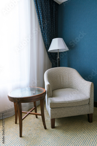 relax concept : vintage chair, wooden table with Lamp on deserted old carpet floor.
classic chair Decoration in livigin room interior with sunlight through the white curtain