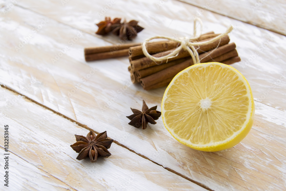 Half of lemon and spices on white wooden table Half of lemon and spices on white wooden table