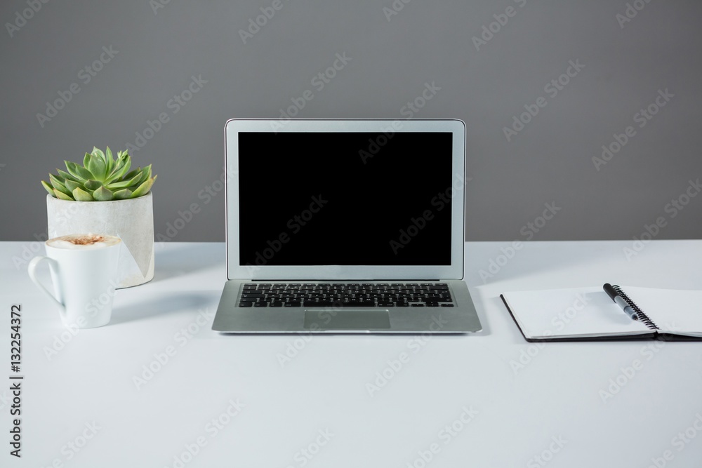 Laptop with cup of coffee and diary Laptop with cup of coffee and diary