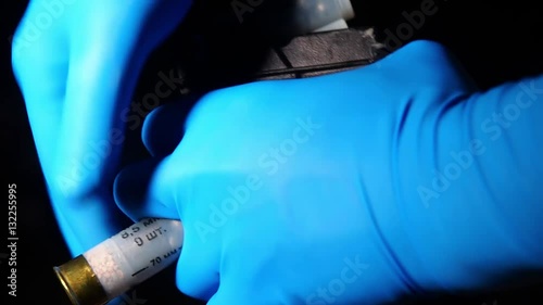 Male hands in blue latex gloves armed automatic rifle hunting ammunition cartridge
