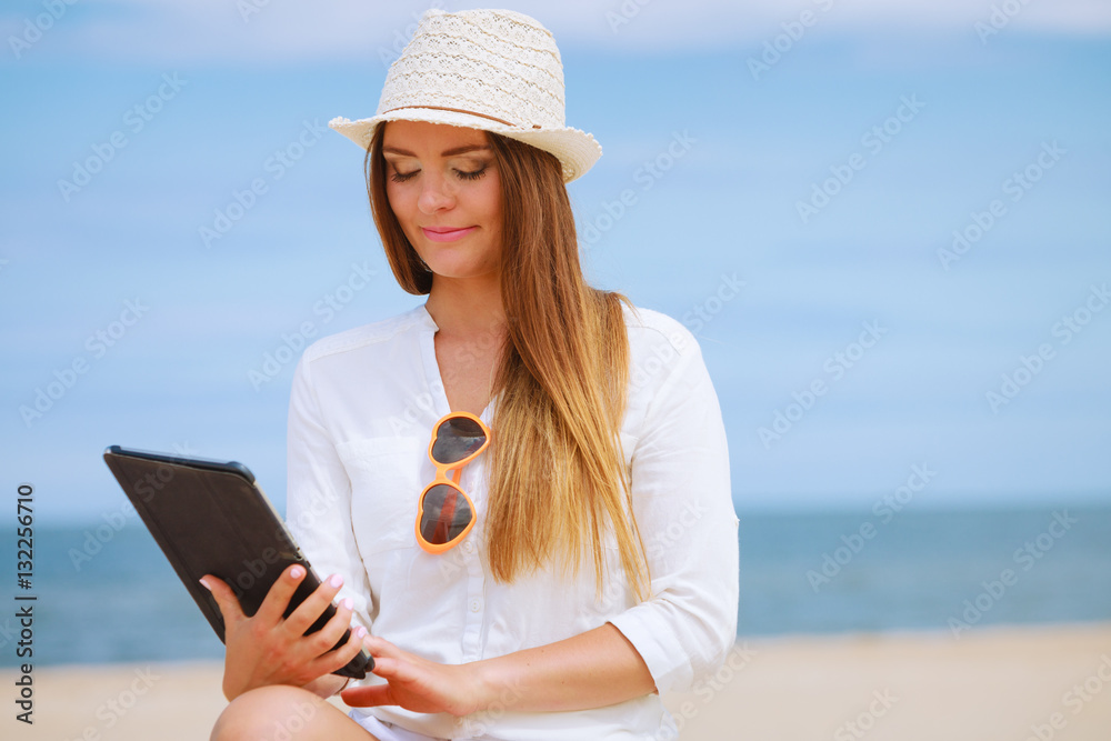 Girl with tablet on seaside.