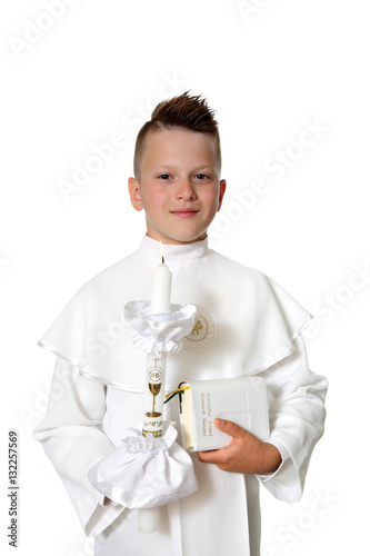 Młody chłopiec w stroju komunijnym na białym tle.
