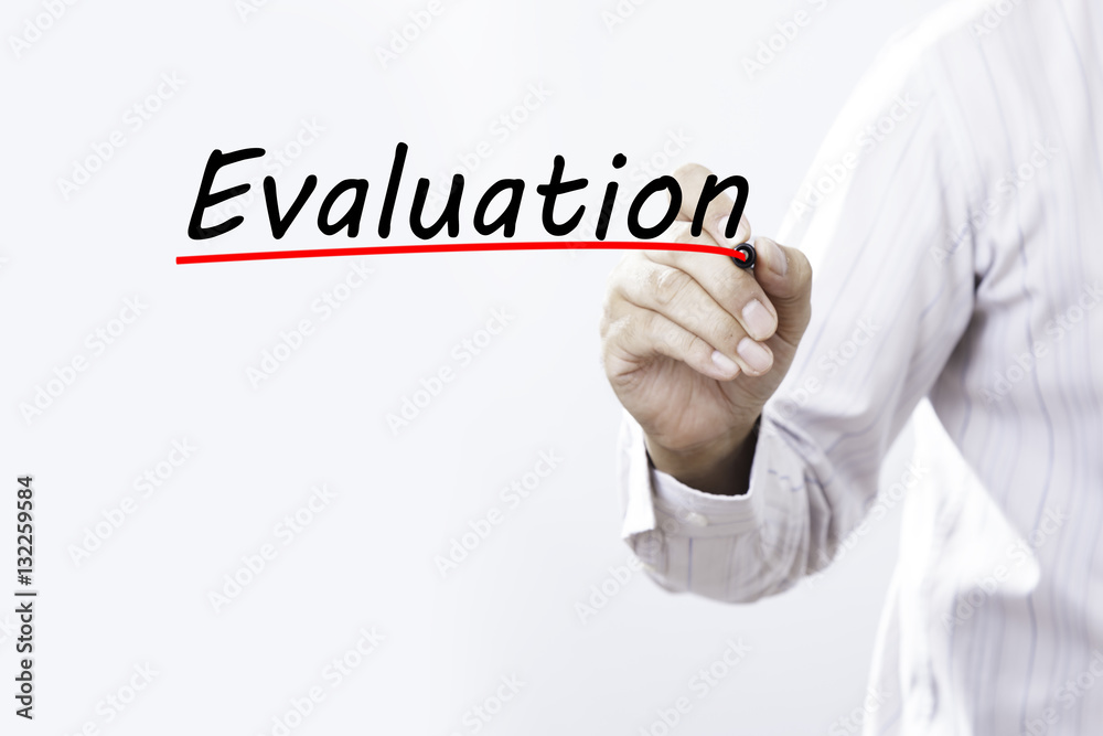 Businessman hand writing evaluation with red marker on transpare Businessman hand writing evaluation with red marker on transpare