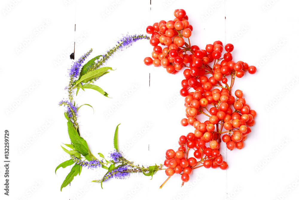 Fototapeta premium Autumn wreath arrangement of berries and flowers on white wooden background view from above