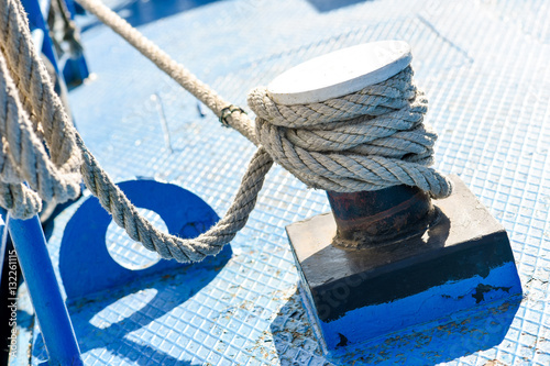 Rope tied to steel bollard on deck in natural light