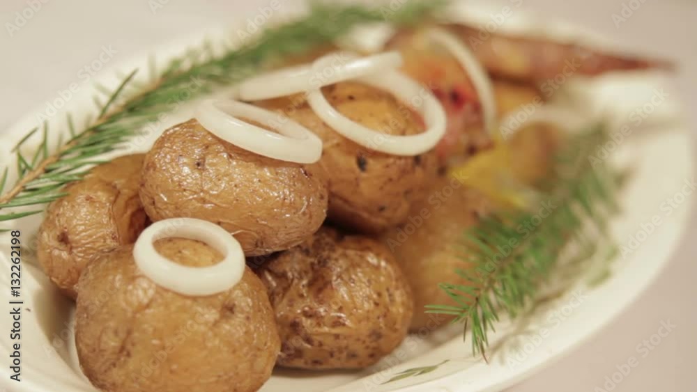 Chicken meats with potatoes in their skins on a plate. Chicken meat, baked on a grill Chicken meats with potatoes in their skins on a plate. Chicken meat, baked on a grill