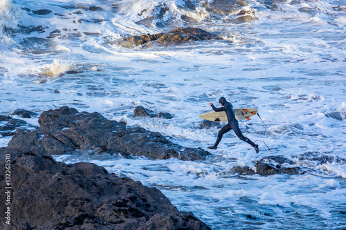 Surfers take advantage of the unusal mild weather with the continued big waves off the west coast.
