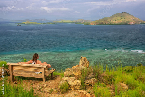 Young woman sitting on a bench at the viewpoint on Kanawa Island © donyanedomam
