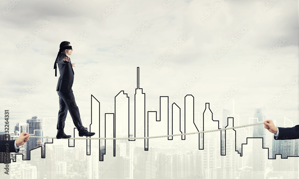 Business concept of risk support and assistance with man balancing on rope Business concept of risk support and assistance with man balancing on rope