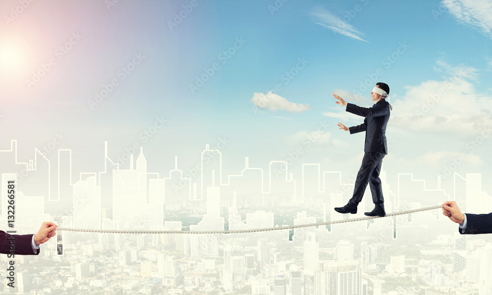 Business concept of risk support and assistance with man balancing on rope Business concept of risk support and assistance with man balancing on rope
