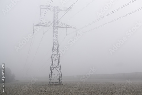 Electricity pylon and the wires against in the mist