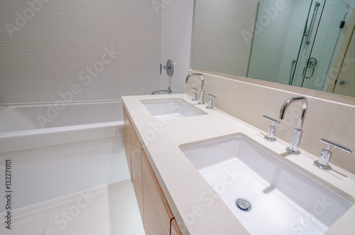 Modern bathroom interior with bathtub and two sinks. 