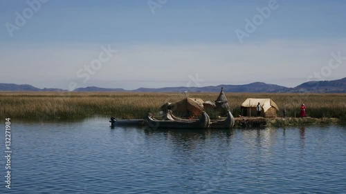 View of the Uros floating reed islands with boats, mysterious Lake Titicaca, Puno Region, Peru