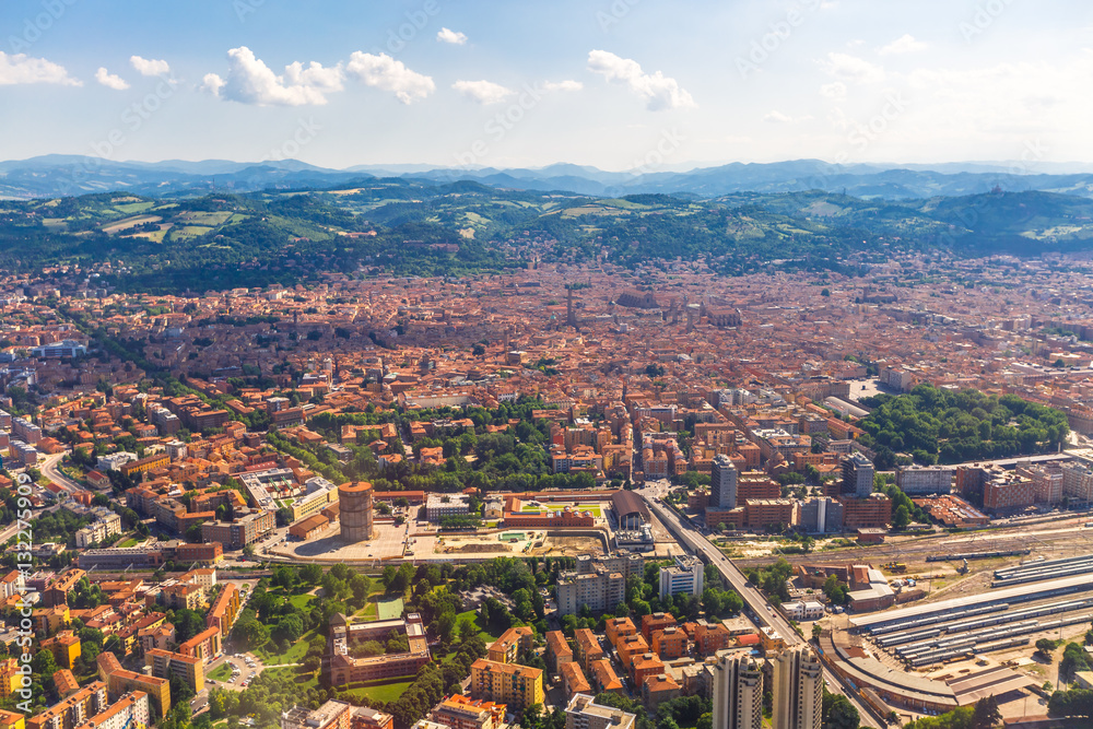 Aerial view of Bologna city in Italy with Asinelli Towers, San Luca Basilica church on Bologna hill and train station.