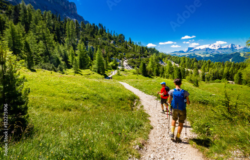 Pair of excursionist walking on mountainous trail. Summer Trekking © meskolo
