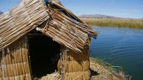 View of the Uros floating reed islands with boats, mysterious Lake Titicaca, Puno Region, Peru