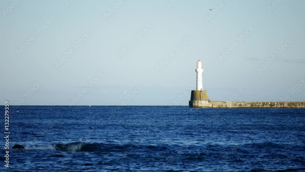 Lighthouse on sunny day in the North Sea Beach, Aberdeen, Scotland
