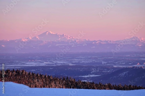 Border between United States and Canada. Snow capped mountain at sunset. View from Grouse Mountain. North Vancouver. British Columbia. Canada.  photo