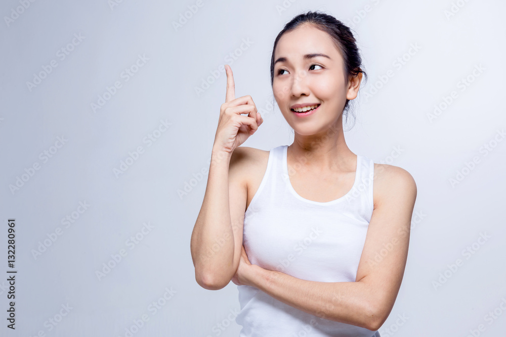 Portrait of a beauty asian smiling girl pointing finger up at co Portrait of a beauty asian smiling girl pointing finger up at co