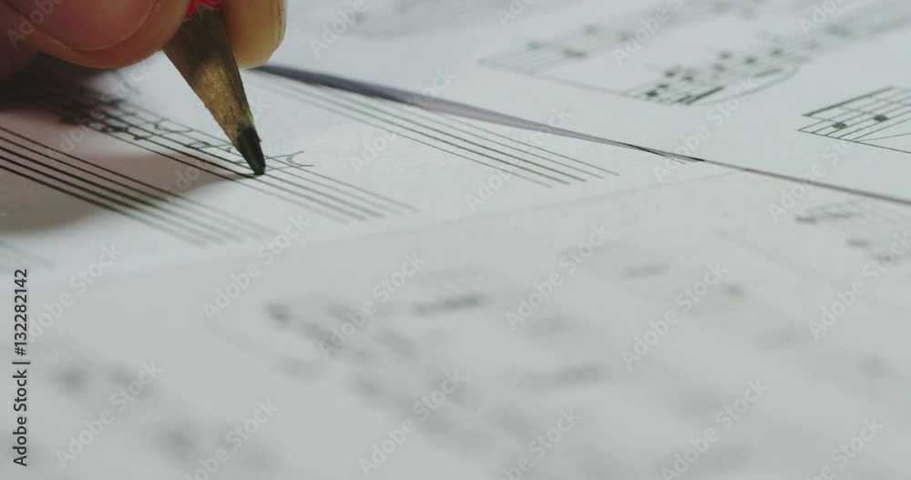 A musician or composer composes a song or a musical work, writing notes in pencil on the pentagram. The composer, first hears the sound of the note then writes and so on is composed the music. Concept
