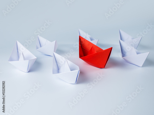 red paper ship leading among white