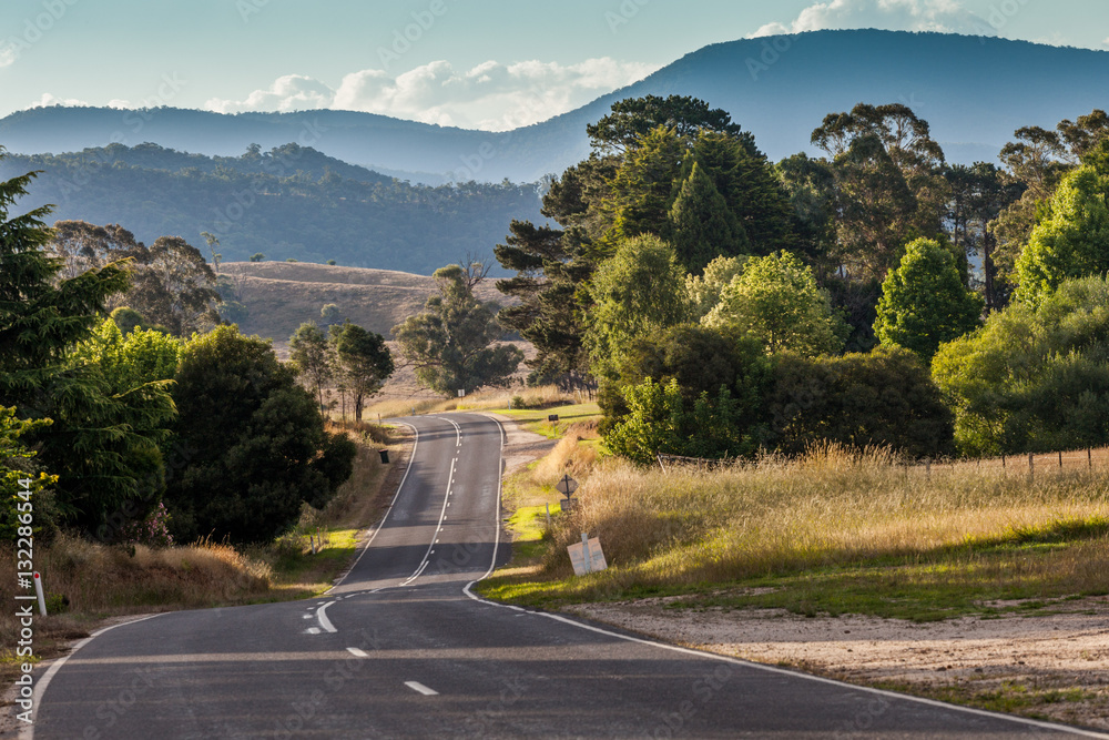 Rural road in Australian countryside at sunset. Mitta Mitta Valley, Victoria, Australia