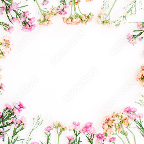 Round frame of colorful wildflowers  green leaves  branches on white background. Flat lay  top view. Valentine s background