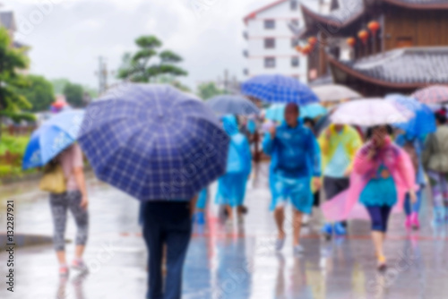 blur of people with umbrella walking in the falling rain