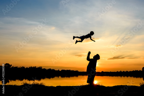 silhouette of father and son at sunset