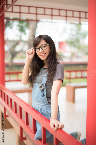 Cheerful beautiful girl in glasses sitting at park
