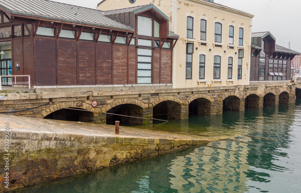 Old arches of stone at the port of Gijon, Spain