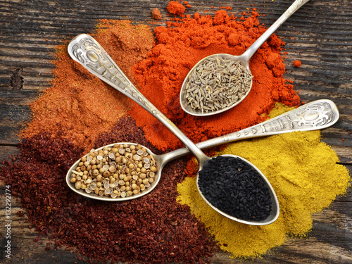 Various colorful spices on a wooden board. View from above