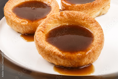 fresh baked yorkshire pudding, british food, with gravy on a pla
