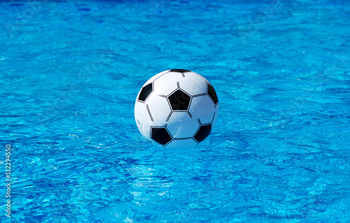 Beach ball floating in blue swimming pool. Space for text. © M-Production