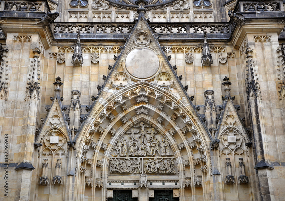 Detail of the main entrance of the Gothic Church of St. Vitus in Prague. Fronton decorated with religious sculpture made of stone.