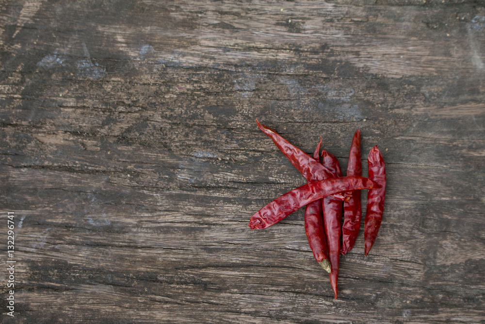 Dried red chilly pepper on wooden panel Dried red chilly pepper on wooden panel