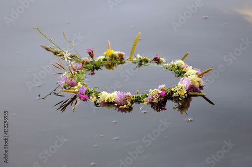 Wreath of flowers floating on the river, close-up.