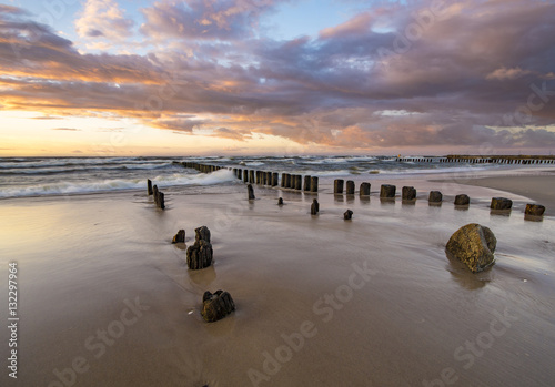 beach and offshore breakwaters during a beautiful sunset, baltic sea 