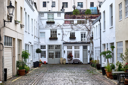 Sussex Mews a short and narrow alley street with cobblestones and low residential houses with vegetation