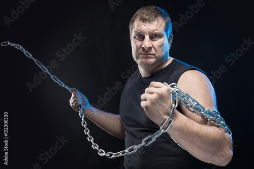 Brutal man actor gesticulates and grimaces on a black background. photo