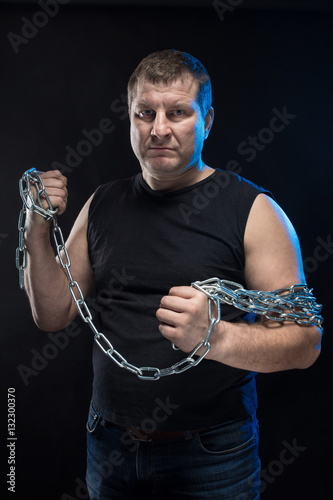 Brutal man actor gesticulates and grimaces on a black background. photo