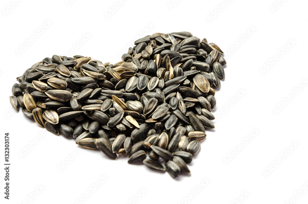 Sunflower seed arrange in heart shape on white background isolated with copy space