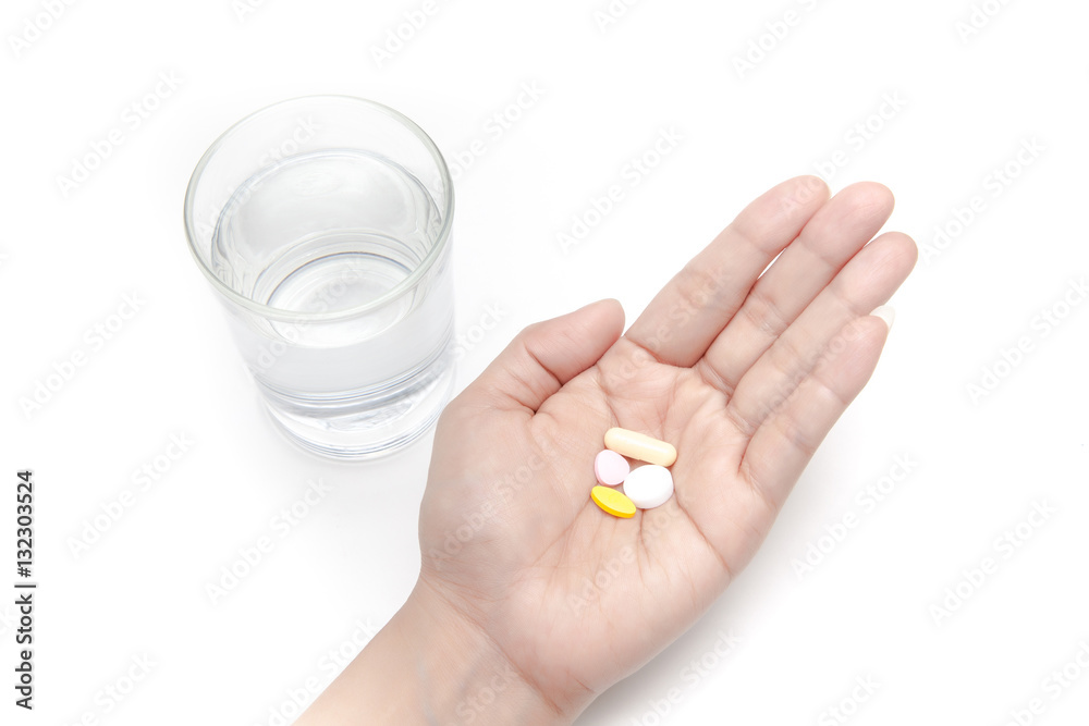 Taking the pills with a glass of drinking water on white background isolated
