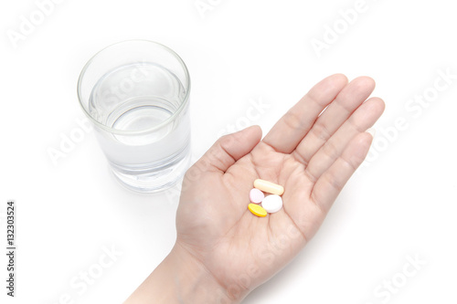 Obraz na płótnie Taking the pills with a glass of drinking water on white background isolated w salonie