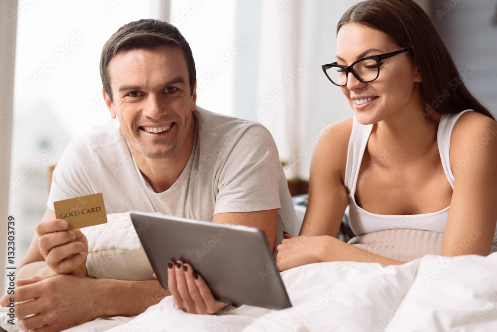 Positive delighted couple shopping online Positive delighted couple shopping online