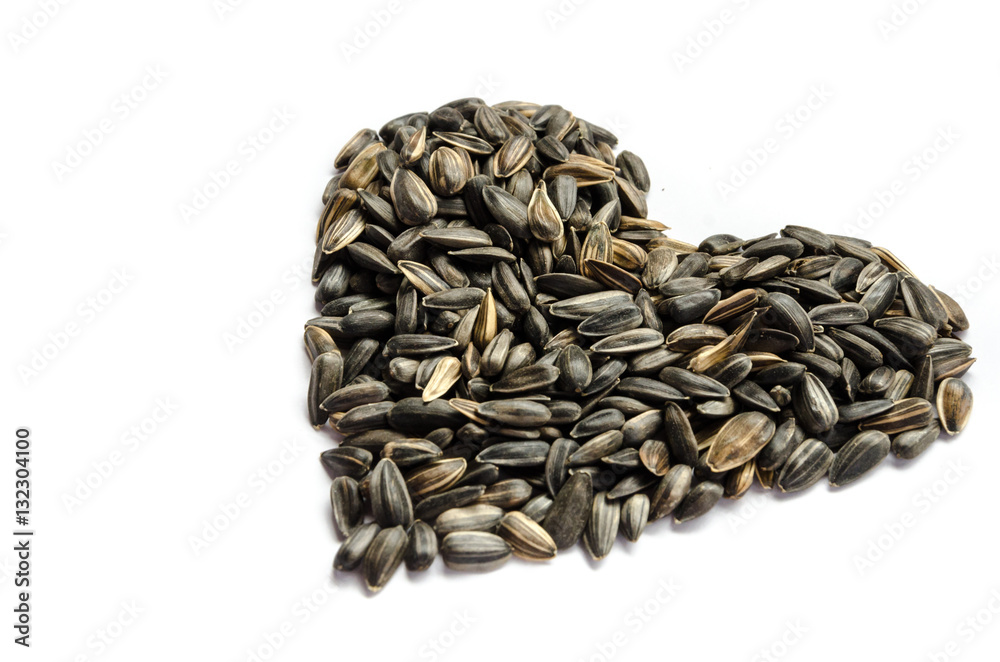 Sunflower seed arrange in heart shape on white background isolated with copy space