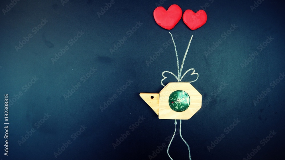 snail compass was tie by red heart shape balloons with wire draw by white chalk on shiny blackboard. valentine/love navigation and travel symbol, vintage background with copy space