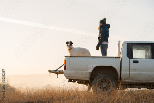 Photography Girl standing on car with dogs in offroad tour